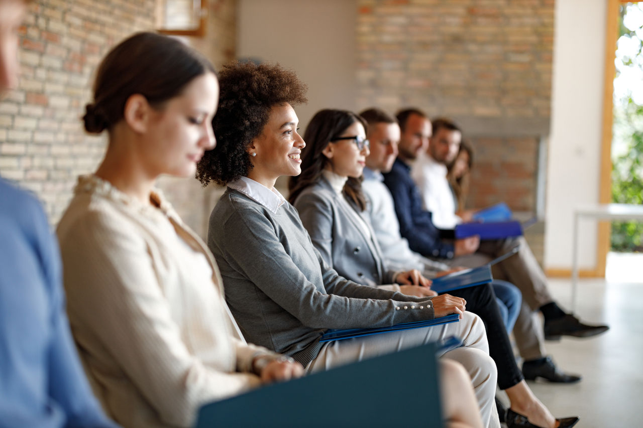group of adults sitting in row at attention