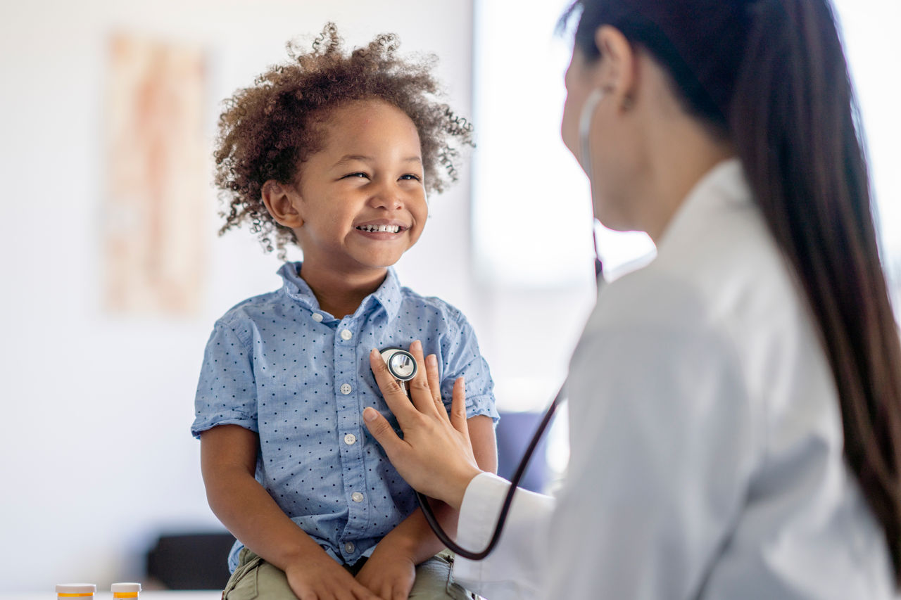 doctor listening to child's heartbeat
